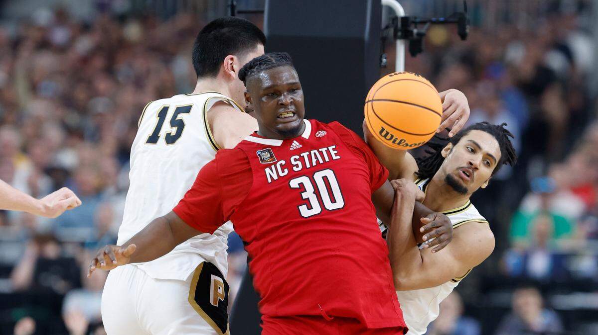 NC State’s DJ Burns battles for the ball with Purdue’s Zach Edney (15) and Trey Kaufman-Renn during the second half of their Final Four game, Saturday, April 6, 2024.