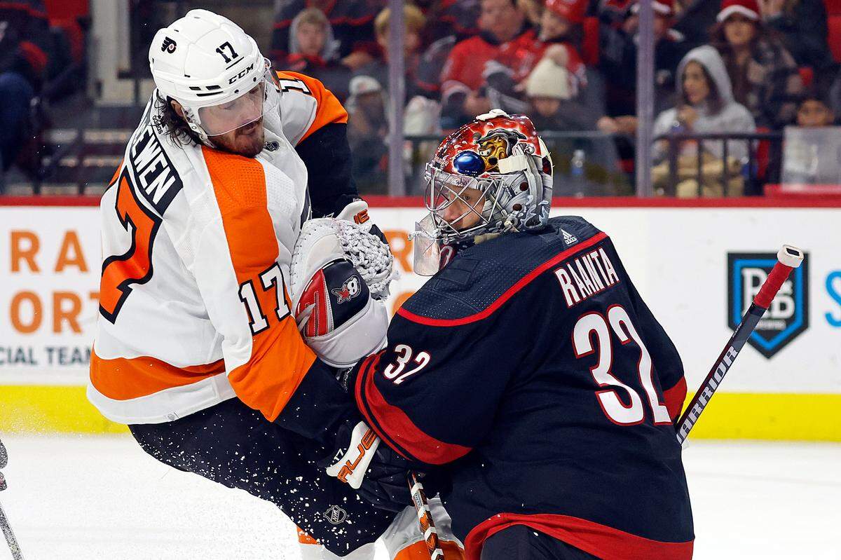 Philadelphia Flyers’ Zack MacEwen (17) collides with Carolina Hurricanes goaltender Antti Raanta (32) during the third period of an NHL hockey game in Raleigh, N.C., Friday, Dec. 23, 2022. (AP Photo/Karl B DeBlaker)