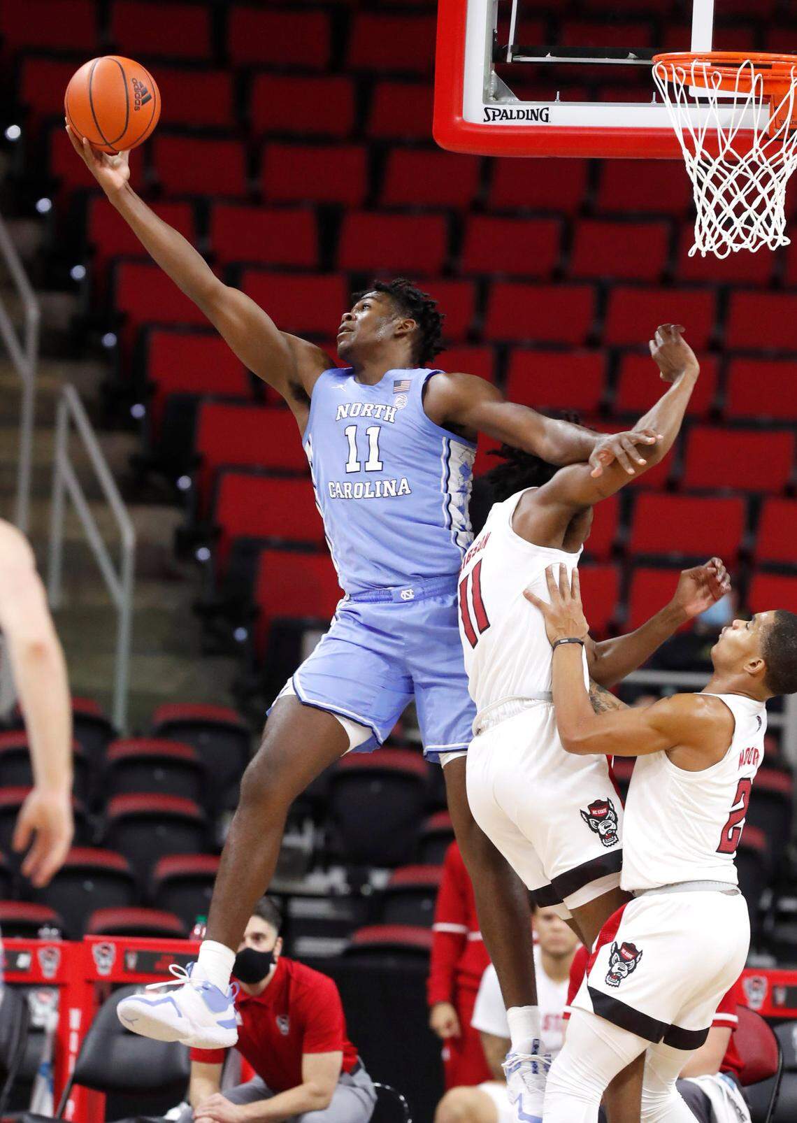 North Carolina’s Day’Ron Sharpe (11) pulls in the rebound in front of N.C. State’s Jaylon Gibson (11) during the second half of N.C. State’s 79-76 victory over UNC at PNC Arena in Raleigh, N.C., Tuesday, December 22, 2020.