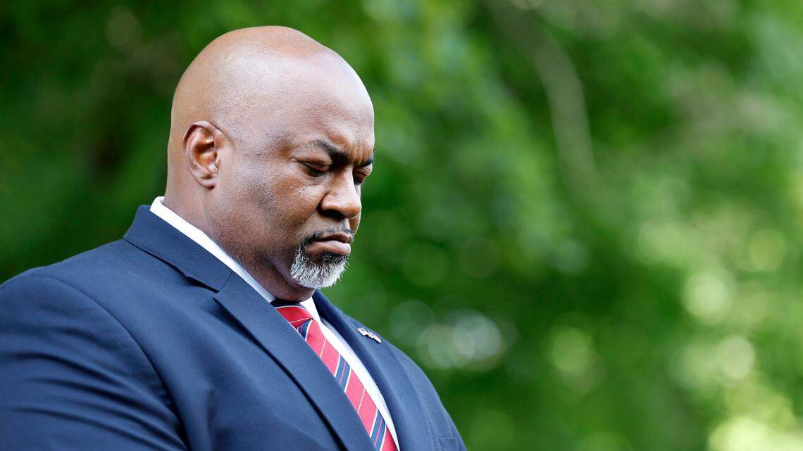 Lt. Gov. Mark Robinson bows his head during the opening prayer at a Moms for Liberty rally outside the Legislative Building in Raleigh, N.C., Wednesday, June 12, 2024.