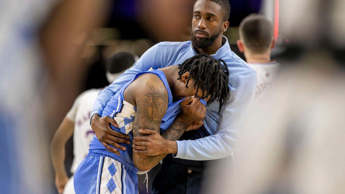 North Carolina graduate assistant Brandon Robinson consoles Caleb Love (2) after Love missed a three-point shot with 2.1 seconds to play securing Kansas’ 72-69 victory in the NCAA Championship game on Monday, April 4, 2022 at Caesars Superdome in New Orleans, La.