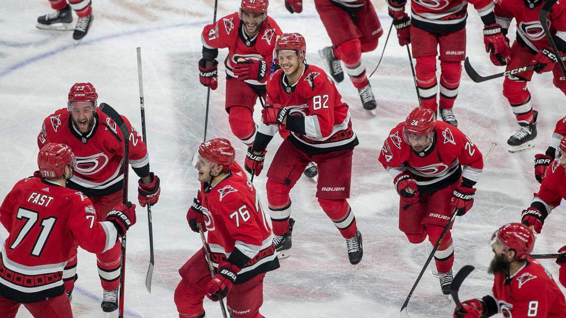 The Carolina Hurricanes swarm to Jesper Fast (71) during their post-game celebration after Fast scored the game winning goal in overtime to secure a 3-2 victory over the New Jersey Devils, clinching their second round Stanley Cup series on Thursday, May 11, 2023 at PNC Arena in Raleigh, N.C.