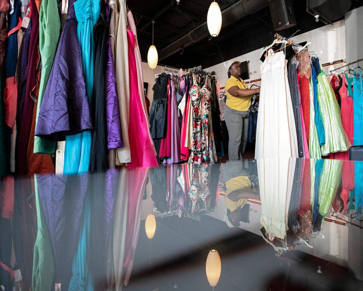 A person looks through racks of dresses during a prom dress drive held by the Hall Foundation at Jonathan’s Sports Lounge & Grill on Wednesday, April 20, 2022, in Raleigh, N.C.