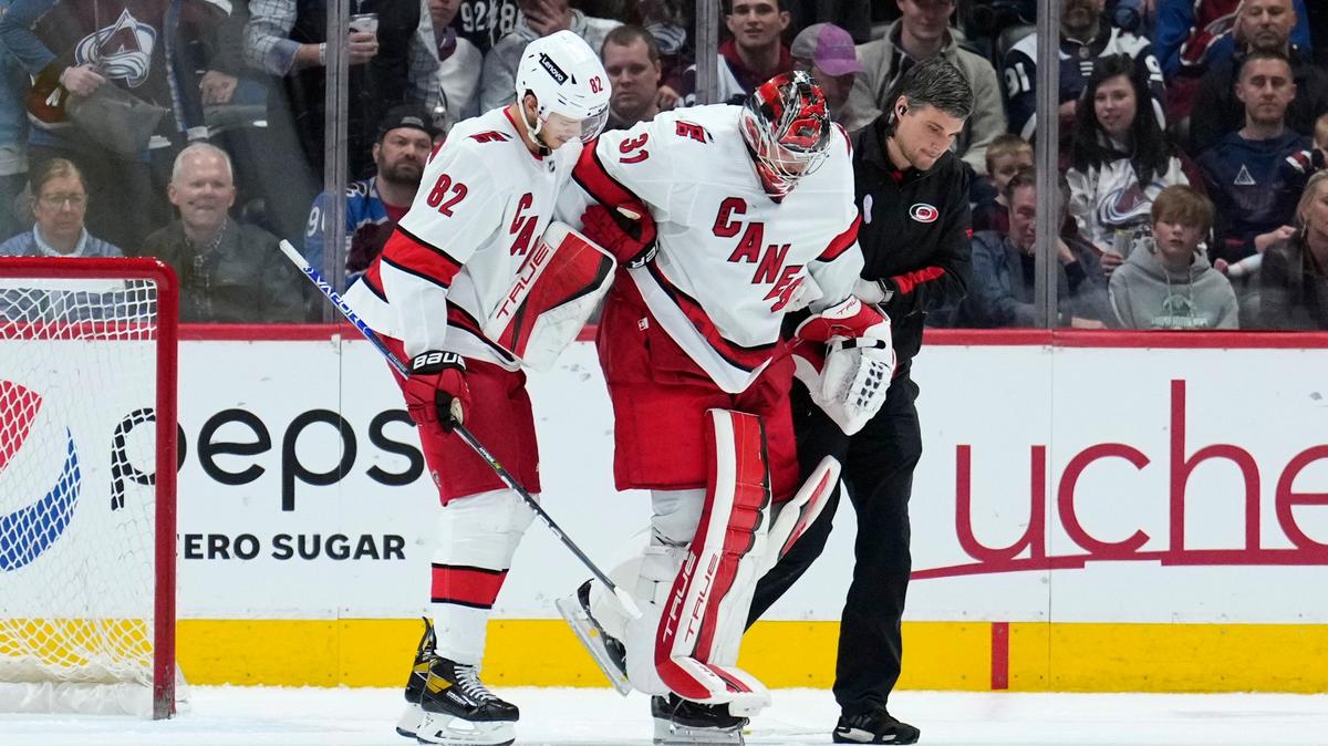 Carolina Hurricanes goaltender Frederik Andersen (31) is helped off the ice by Jesperi Kotkaniemi (82) and a trainer during the third period of the team’s NHL hockey game against the Colorado Avalanche on Saturday, April 16, 2022, in Denver. (AP Photo/Jack Dempsey)