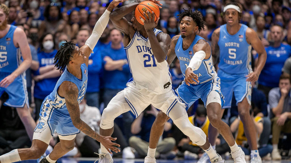 North Carolina’s Leaky Black (1) and Caleb Love (2) trap Duke’s A.J. Griffin (21) during the second half on Saturday, March 5, 2022 at Cameron Indoor Stadium in Durham, N.C.