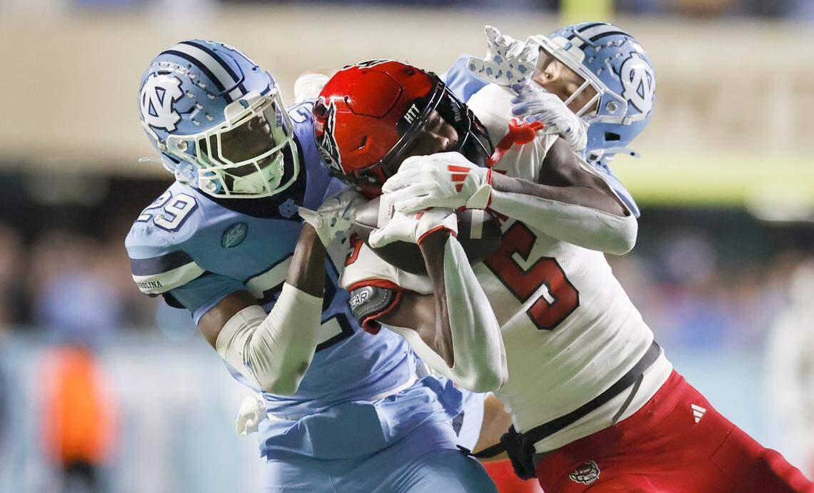 N.C. State wide receiver Noah Rogers (5) pulls in a 44-yard reception while being defended North Carolina’s Marcus Allen (29) and Will Hardy (31) late in the fourth quarter of N.C. State’s 35-30 victory over UNC at Kenan Stadium in Chapel Hill, N.C., Saturday, Nov. 30, 2024.