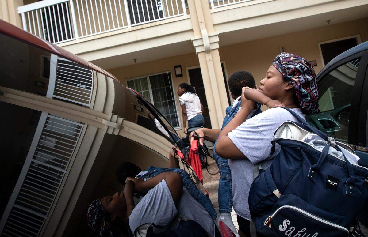Bri’Najasha McCullers holds her one-year-old son, Sahkahanii, grandson of LaSherron Geddie, as they make their way to LaSherron Geddie’s room at an extended-stay hotel in Raleigh, N.C. on Monday, July 25, 2022.