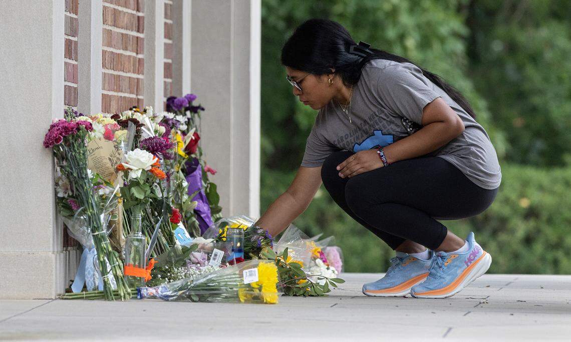 Ashley Vicente Lopez, a first-year student at UNC-Chapel Hill, leaves flowers at a memorial at the base of the bell tower on Wednesday, Aug. 30, 2023, in Chapel Hill, N.C. A graduate student has been charged with first-degree murder following a Monday shooting that left physics professor Zijie Yan dead on the university’s campus.