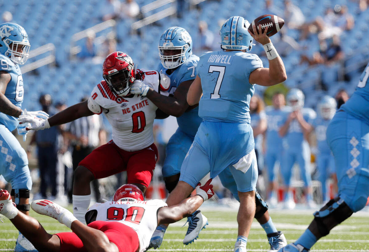 N.C. State defensive end Savion Jackson (90) tries to stop North Carolina quarterback Sam Howell (7) during the second half of UNC’s 48-21 victory over N.C. State at Kenan Stadium in Chapel Hill, N.C., Saturday, Oct. 24, 2020.