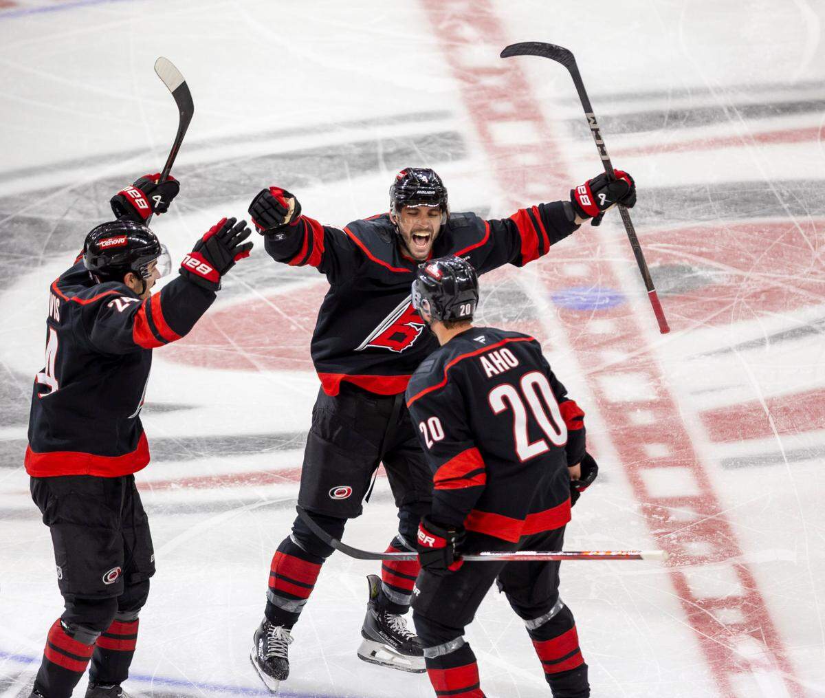 Carolina Hurricanes center Sebastian Aho (20) celebrates with teammates Shaye Gostisbehere (04) and Seth Jarvis (24) after scoring the game winning goal in double overtime to secure a 5-4 victory and clinch the first round Stanley Cup series over the New Jersey Devils on Tuesday, April 29, 2025 at Lenovo Center in Raleigh, N.C.