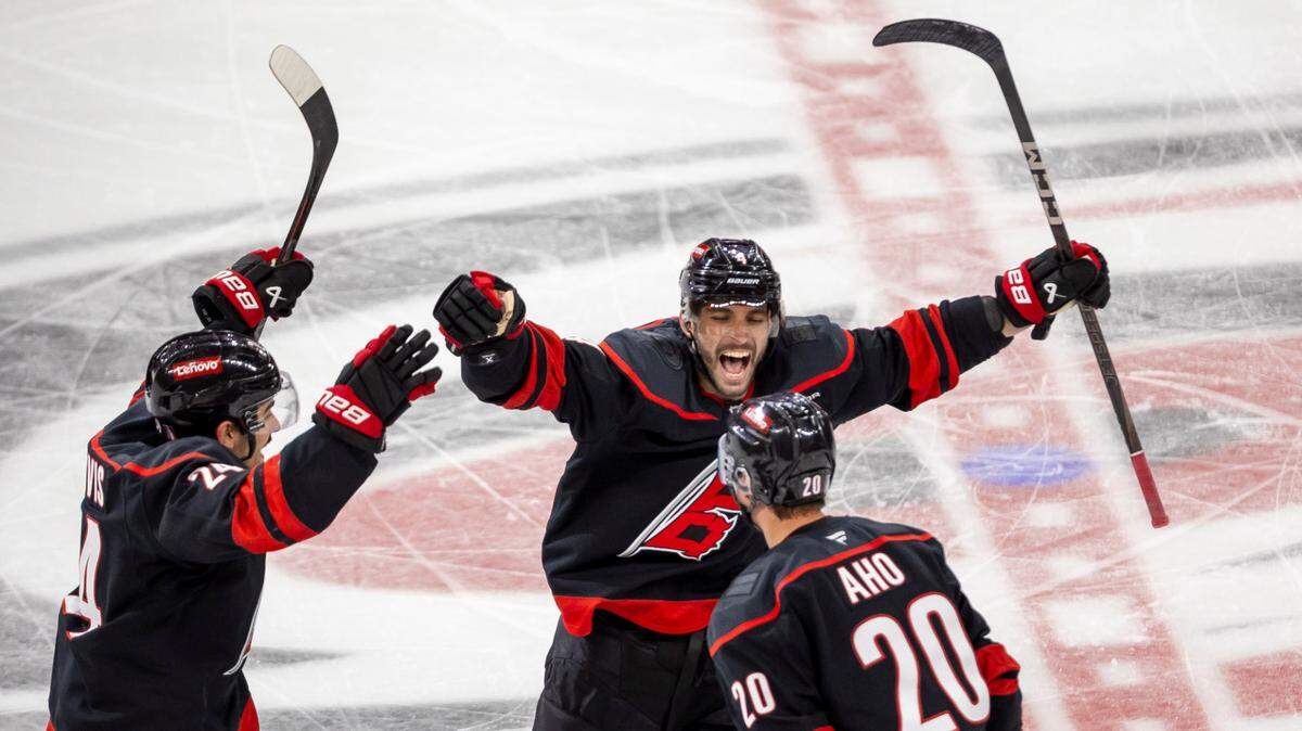Carolina Hurricanes center Sebastian Aho (20) celebrates with teammates Shaye Gostisbehere (04) and Seth Jarvis (24) after scoring the game winning goal in double overtime to secure a 5-4 victory and clinch the first round Stanley Cup series over the New Jersey Devils on Tuesday, April 29, 2025 at Lenovo Center in Raleigh, N.C.