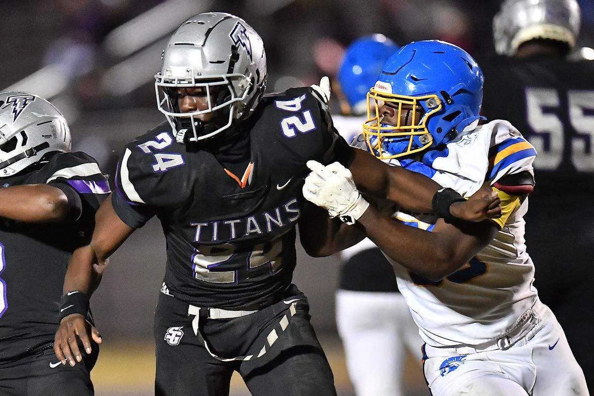 South Garner defensive end Ebenezer Ewetade (24) contends with Garner linebacker Raheem Ross (50) during the second half. The South Garner Titans and the Garner Trojans met in a conference football game in Raleigh, N.C. October 17, 2025