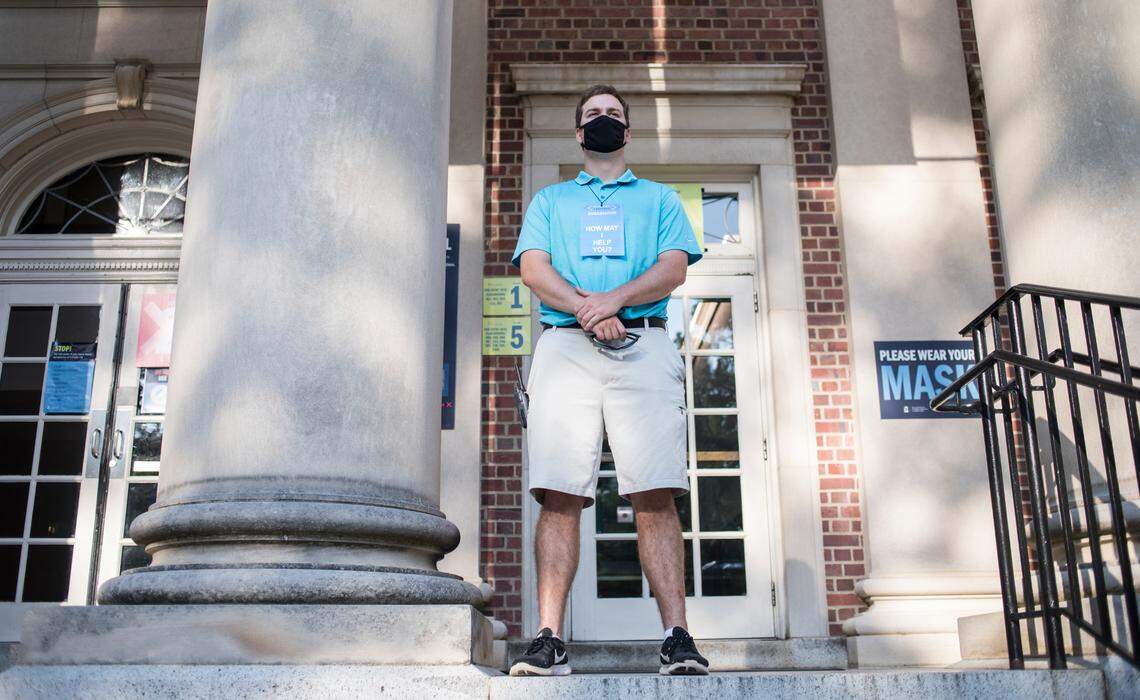 University ambassador Alex Laws stands outside Carroll Hall on UNC-Chapel Hill’s campus on Monday, Aug. 10, 2020, to answer questions about COVID-19 precautions and help facilitate movement into and out of the building.