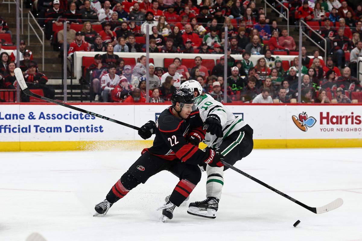 Logan Stankoven (22) of the Carolina Hurricanes skates with the puck while defended by Oskar Bäck of the Dallas Stars during the second period at Lenovo Center on Jan. 6, 2026 in Raleigh, North Carolina.