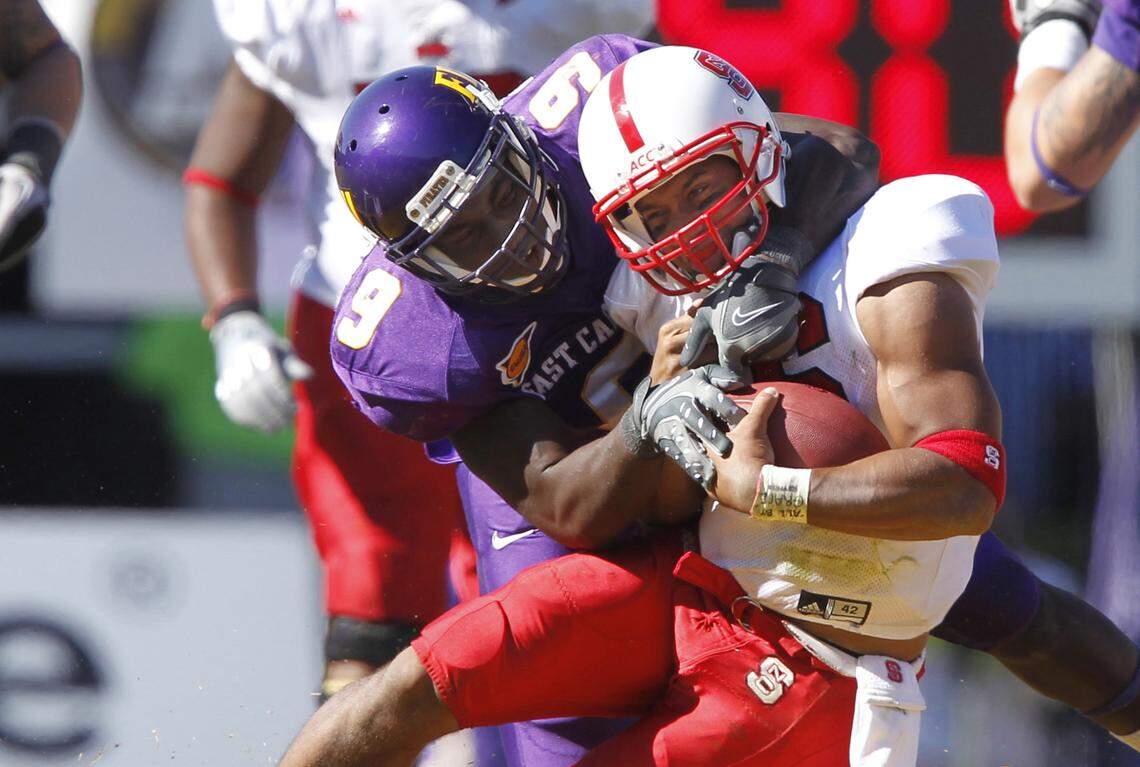 East Carolina’s Melvin Patterson (9) brings down N.C. State’s Russell Wilson during the Pirates’ 33-27 overtime victory over the Wolfpack in Greenville in 2010.