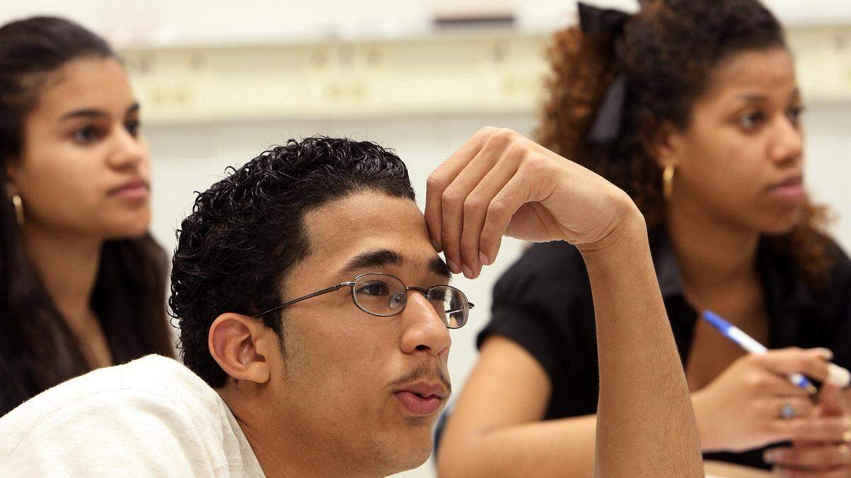 Millbrook High School student Edgar DeLeon-Molina intently watches a scene in a movie during his English as a Second Language class on March 19, 2008. The class was watching "Miracle," the story of the 1980 U.S. hockey team winning the gold medal at the Winter Olympics. The students would watch a portion of the movie and then discuss the nuances of it. Also visible are Darisa Paez Santana (left) and Denny Cruz (right).