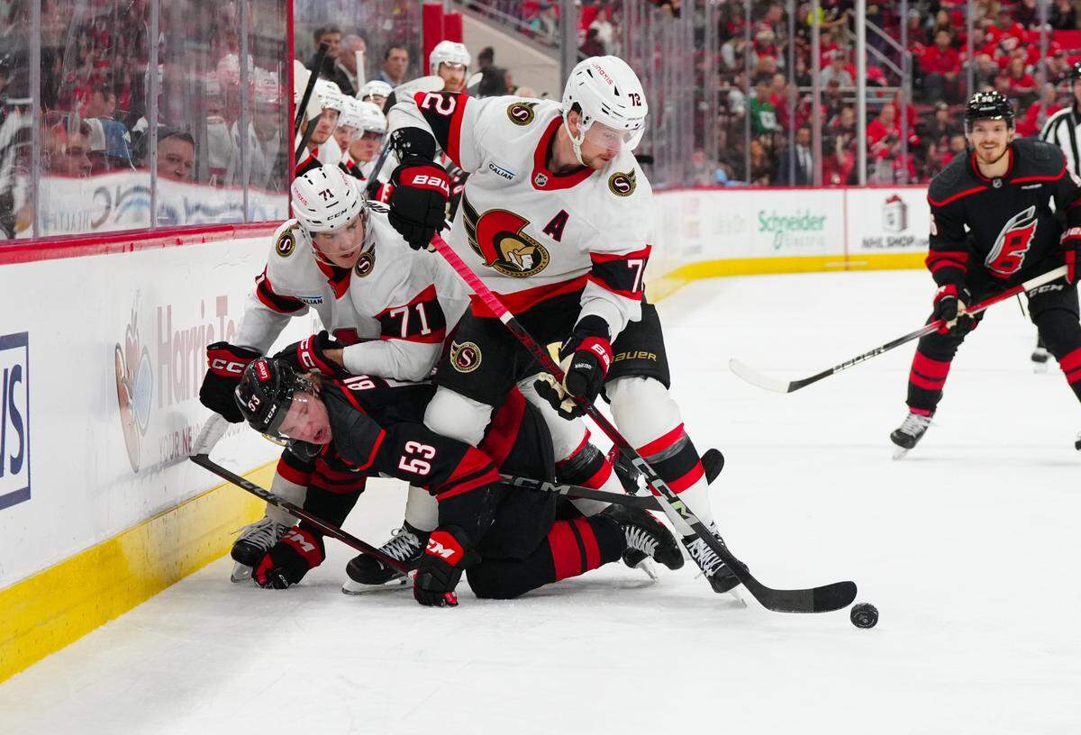 Ottawa Senators defenseman Thomas Chabot (72) and center Ridly Greig (71) battle for the puck against Carolina Hurricanes right wing Jackson Blake (53) during the first period at Lenovo Center.
