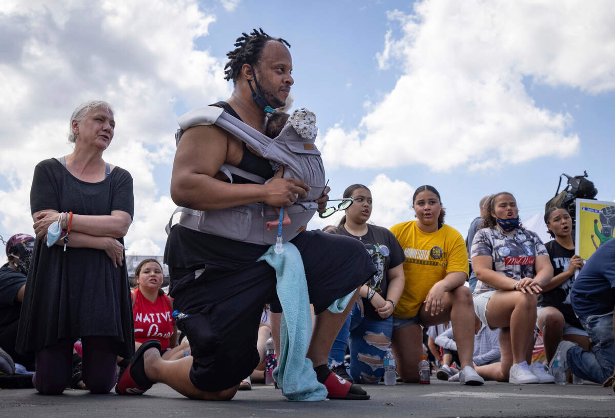 People take a knee during a moment of silence on the one year anniversary of George Floyd’s death on Tuesday, May 25, 2021, in Minneapolis.