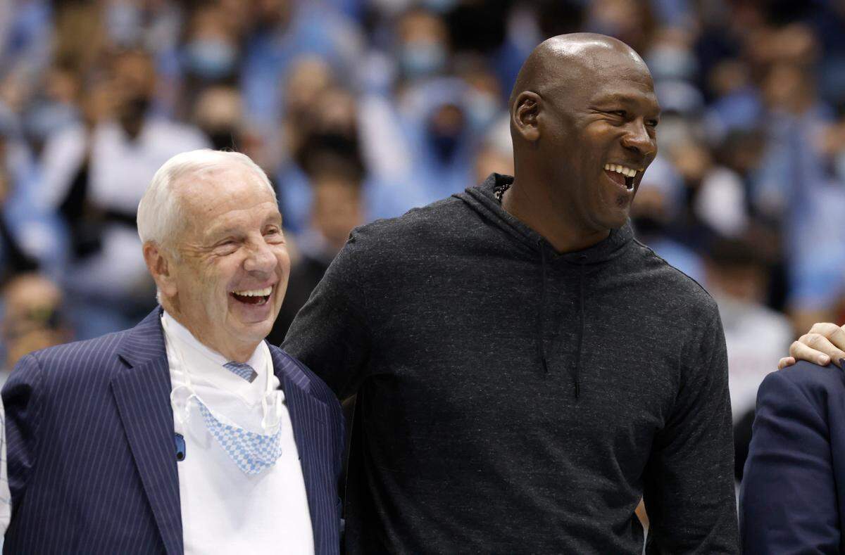 Roy Williams laughs with Michael Jordan as the 1981-82 North Carolina national champion basketball team is honored during UNC’s 100-80 victory over N.C. State at the Smith Center in Chapel Hill, N.C., Saturday, Jan. 29, 2022.