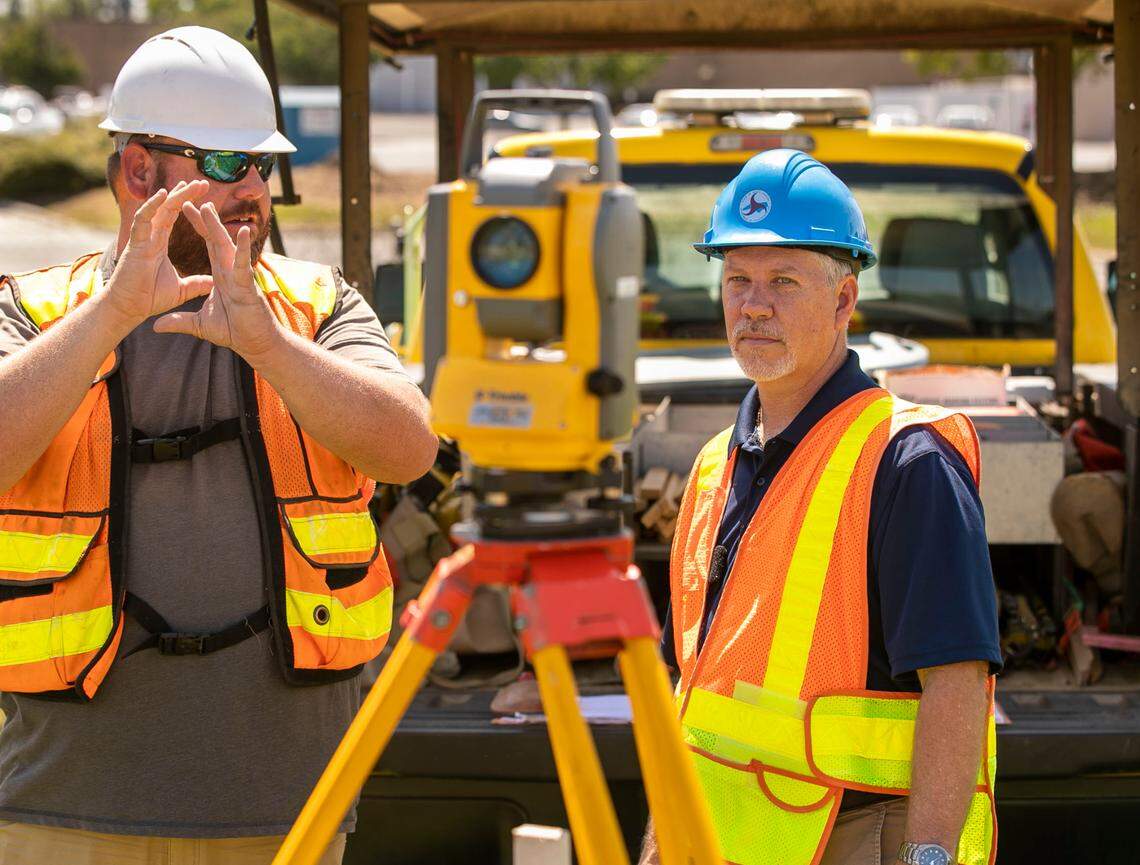 NCDOT district engineer Dan Cumbo, right, inspects survey markers for a new bridge with engineering technician John Peede on Wednesday, April 13, 202 in Clinton, N.C.