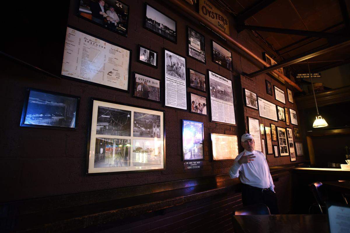 Longtime 42nd Street Oyster Bar owner Brad Hurley stands with a wall of restaurant artifacts.