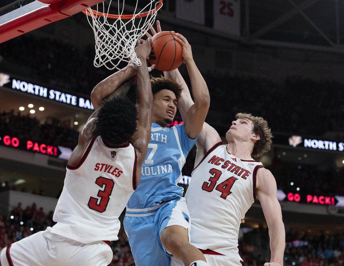 North Carolina’s Seth Trimble drives to the basket against N.C. State’s Dontrez Styles and Ben Middlebrooks during the first half of the Tar Heels’ game at Lenovo Center on Saturday, Jan. 11, 2025, in Raleigh, N.C.