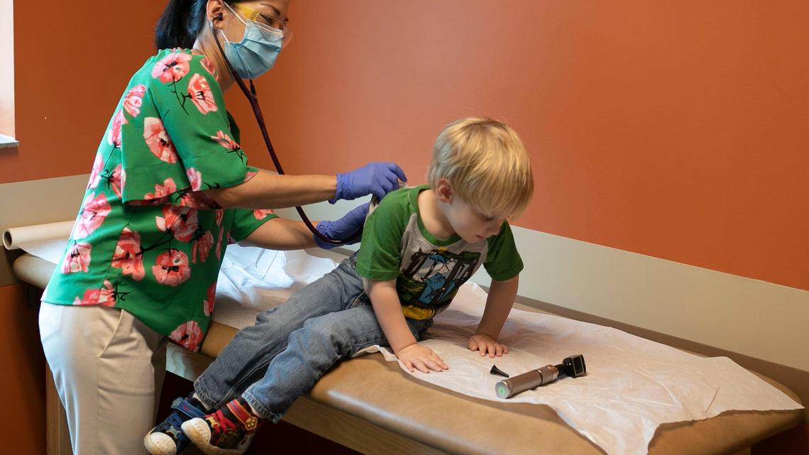 Dr. Yun Boylston coaxes three-year-old patient Reid Nielsen into better posture as she listens to his lungs during a well visit at Mebane Pediatrics on Monday, May 18, 2020 in Mebane, N.C.