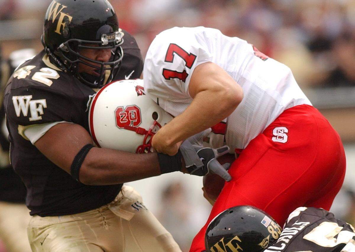 Wake Forest’s (42) Jamaal Argrow and (85) Jerome Nichols sack N.C. State quarterback (17) Philip Rivers their game in Groves Stadium in Winston-Salem in 2003.
