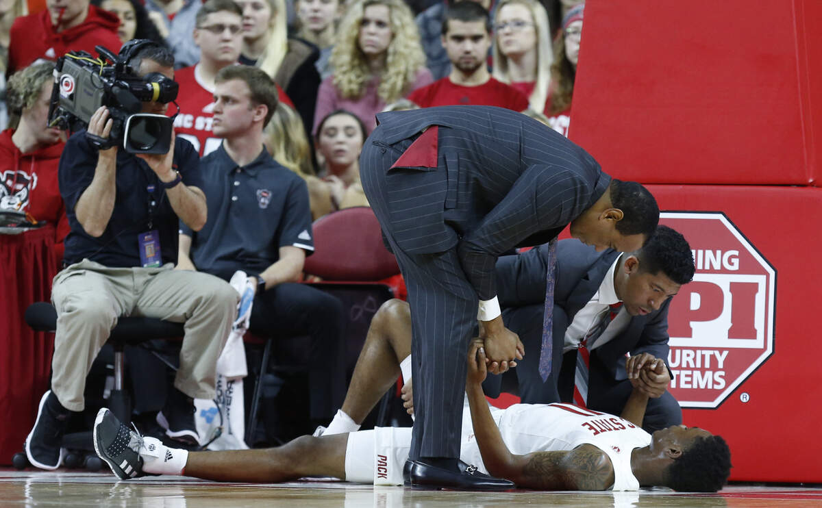 N.C. State head coach Kevin Keatts and trainer Drew Moore check on Markell Johnson (11) during the first half of N.C. State’s game against Pittsburgh at PNC Arena in Raleigh, N.C., Saturday, Jan. 12, 2019.