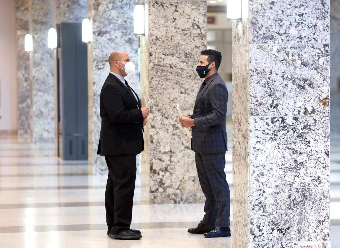 Attorneys Pooyan Ordoubadi, left, and Esteban Diaz talk while at the Wake County Justice Center in Raleigh, N.C., Wednesday morning, July 28, 2021. Both attorneys said the rise of the Delta Variant hasnÕt changed their thinking on masks; they never stopped wearing their masks while inside the justice center.