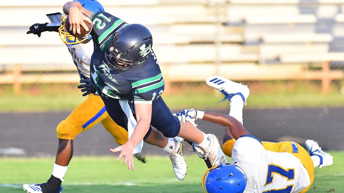 Leesville’s Vince Amendola (12) dives across the goal line for the touchdown against Garner’s Terrell Chance (17) and Ahkee Vaughan (4) during the second quarter.  The Leesville Road Pride and the Garner Trojans met in a non-conference football game in Raleigh, N.C. on September 12, 2018.