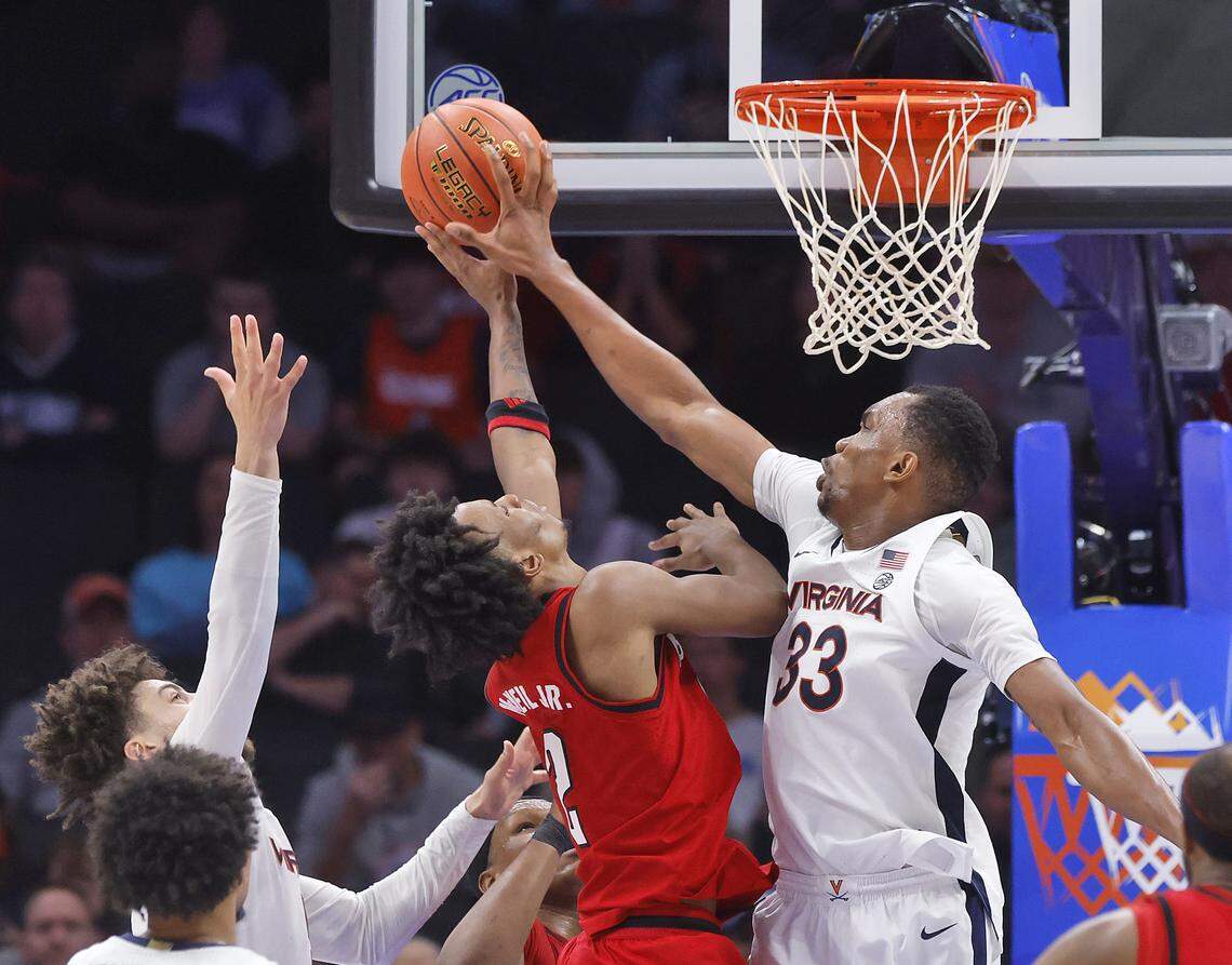 Virginia's Ugonna Onyenso blocks a shot by N.C. State's Paul McNeil Jr. during the second half of the Wolfpack’s 81-74 loss in the ACC Tournament quarterfinals on Thursday, March 12, 2026, at the Spectrum Center in Charlotte, N.C. 