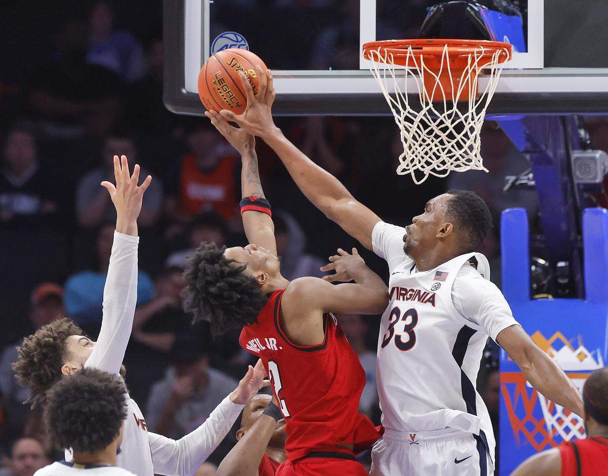 Virginia's Ugonna Onyenso blocks a shot by N.C. State's Paul McNeil Jr. during the second half of the Wolfpack’s 81-74 loss in the ACC Tournament quarterfinals on Thursday, March 12, 2026, at the Spectrum Center in Charlotte, N.C.