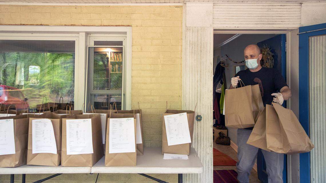 Thomas Blaine organizes bags of bread to be delivered to customers’ porches by Strong Arm Baking, co-owned with his wife Julia Blaine, as they work to change their business model to adapt to COVID-19, on Thursday, Apr. 23, 2020, in Franklinton, N.C.