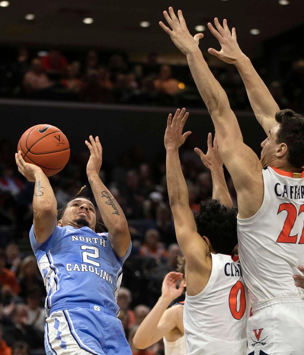 Virginia’s Kihei Clark (0) and Francisco Caffaro (22) defend North Carolina’s Cole Anthony (2) during the first half on Sunday, December 8, 2019 at John Paul Jones Arena in Charlottesville, Va.