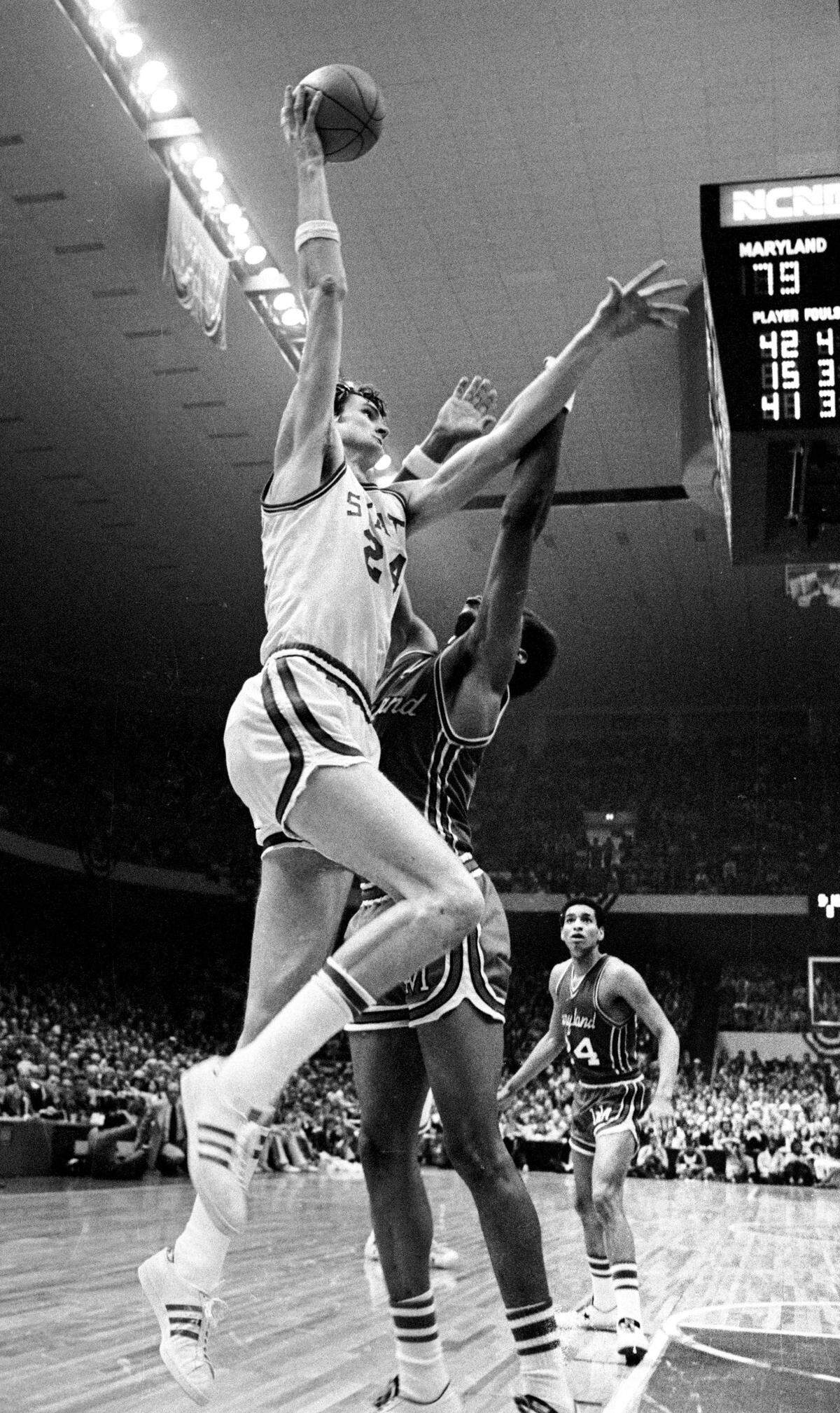 NC State center Tommy Burleson goes up for a shot over Maryland center Len Elmore late in the Wolfpack’s ACC Tournament game against Maryland in 1974.
