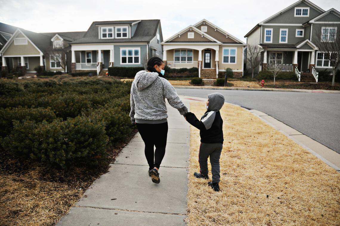 Laurel Farrar, left, with her six-year-old son, Jaiden Rodgers, in their Chapel Hill neighborhood on Tuesday, Jan 19, 2021. Rodgers, who is non-verbal, is struggling with online school so Farrar tries to fit in a lot of one-on-one time with her first grader while juggling a full-time job and her daughter.