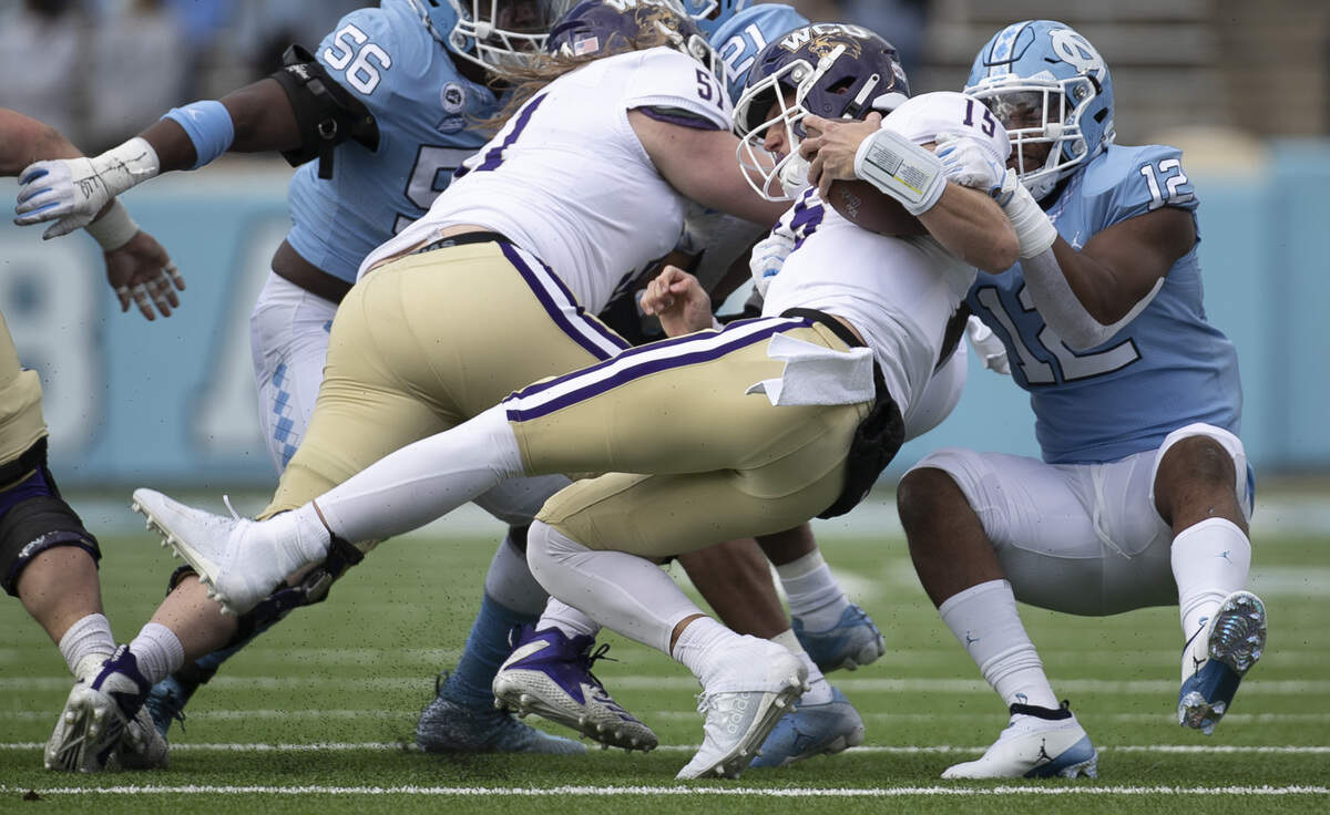 Western Carolina quarterback Will Jones (15) is sacked by North Carolina’s Tomon Fox (12) in the first quarter on Saturday, December 5, 2020 at Kenan Stadium in Chapel Hill, N.C.