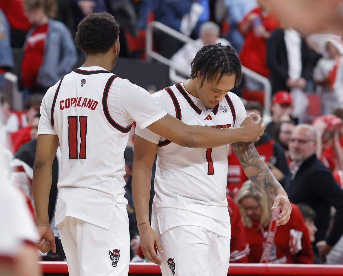 N.C. State’s Quadir Copeland embraces teammate Darrion Williams after Williams’ shot was no good with one second remaining in overtime of the Wolfpack’s 77-76 loss to Kansas on Saturday, Dec. 13, 2025, at Lenovo Center in Raleigh, N.C.