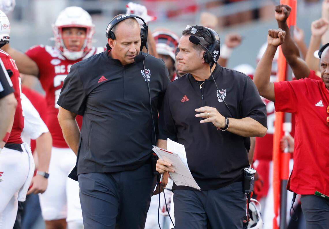 N.C. State head coach Dave Doeren, left, talks with offensive coordinator Tim Beck during the second half of N.C. State’s 27-21 overtime victory over Clemson at Carter-Finley Stadium in Raleigh, N.C., Saturday, Sept. 25, 2021.