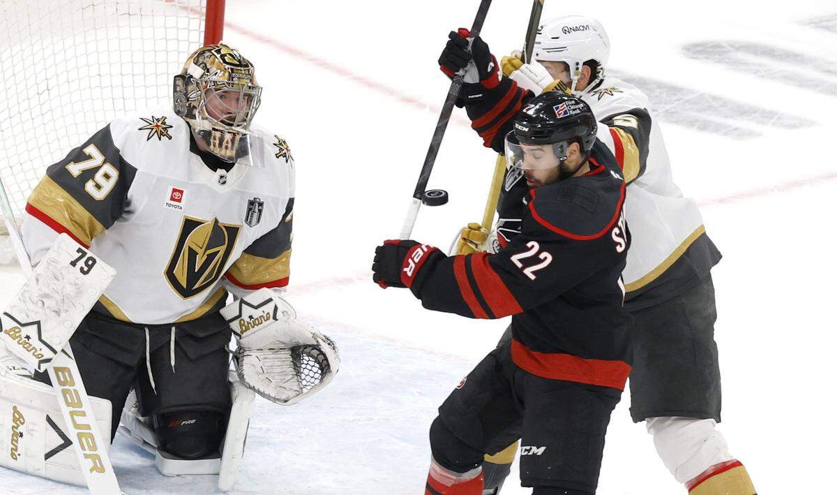 Carolina's Logan Stankoven (22) battles with Vegas' Jeremy Lauzon (5) in front of the goal in the first period of the Hurricanes’ game against the Golden Knights in the second game of the Stanley Cup Final at the Lenovo Center in Raleigh, N.C., Thursday, June 4, 2026.