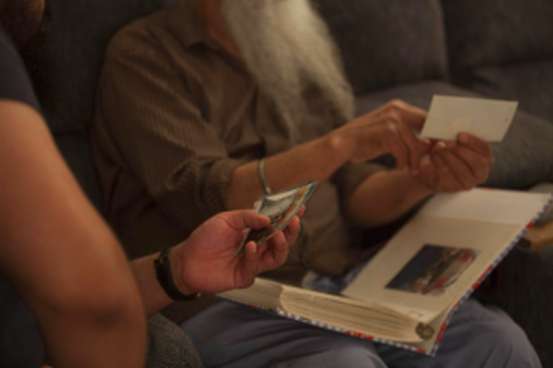 Gurmit and RJ look through old pictures together, many documenting Gurmit’s life before coming to America.