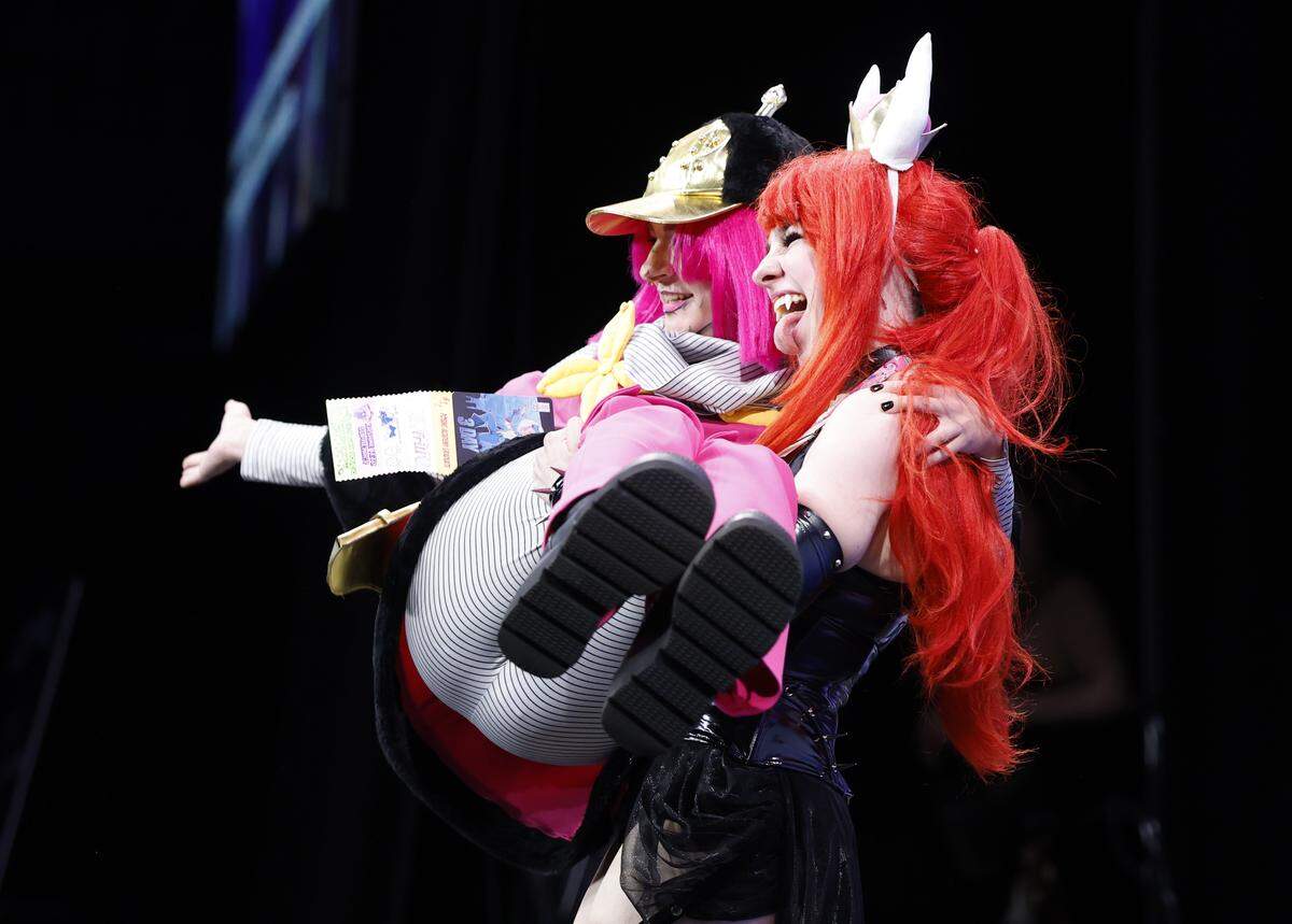 Wren Gutierrez of Wilmington jumps into the arms of Naomi Johnson of Matthews during the Runway Costume Contest at GalaxyCon Raleigh at the Raleigh Convention Center Friday, July 25, 2025. Gutierrez is cosplaying as Hot Pants from JoJo’s Bizarre Adventure and Johnson is playing Bowsette from Super Mario.