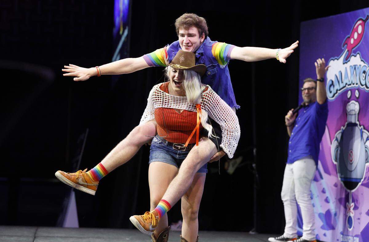 Olivia Van Sickle of New Bern carries Ryan Mertz of Raleigh off the stage during the Runway Costume Contest at GalaxyCon Raleigh at the Raleigh Convention Center Friday, July 25, 2025. Van Sickle is cosplaying My Little Pony’s Applejack and Mertz is Rainbow Dash. 