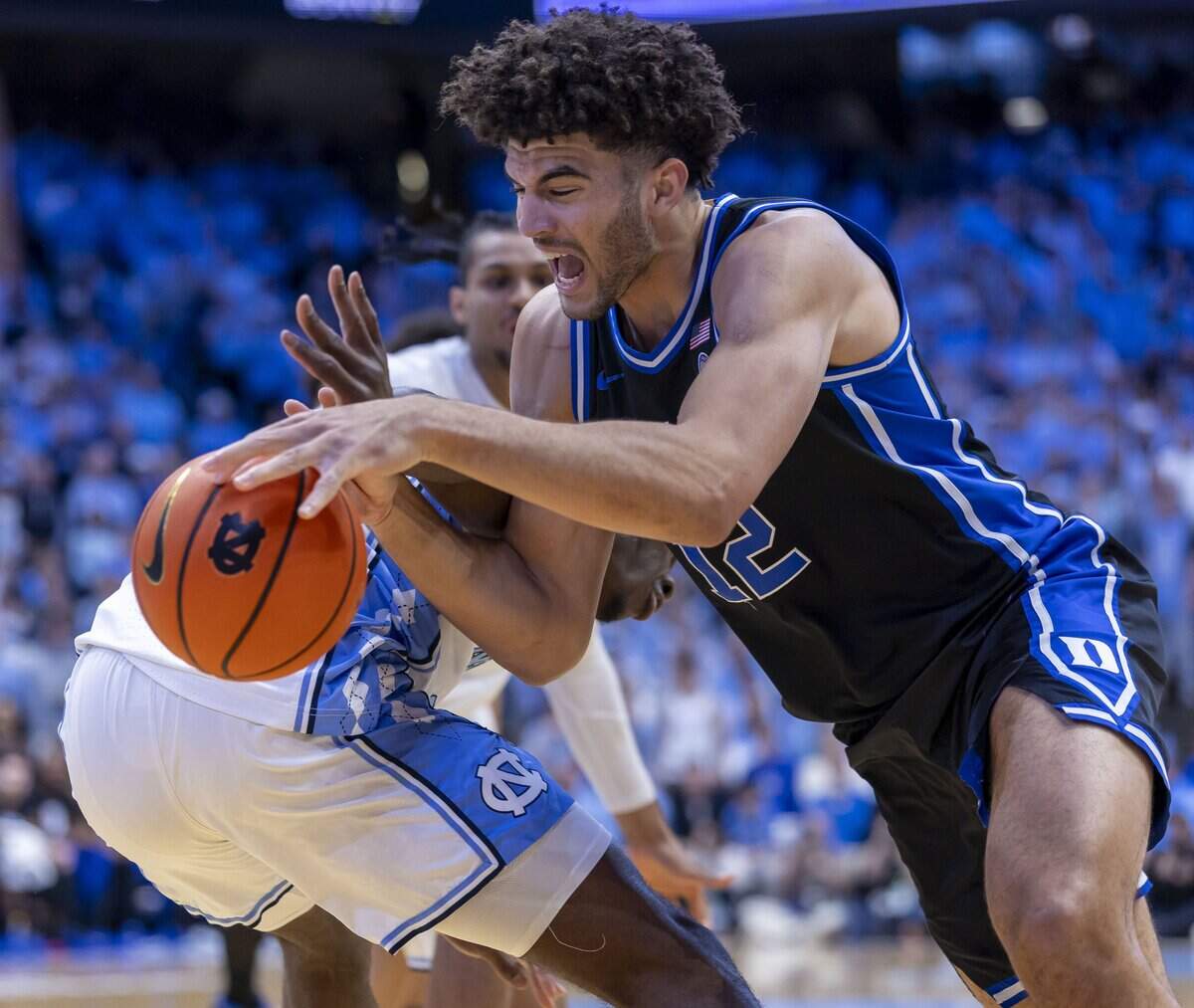 Duke forward Cameron Boozer (12) drives around North Carolina forward Caleb Wilson (8) in the first half on Saturday, February 7, 2026 at the Smith Center in Chapel Hill, N.C.  