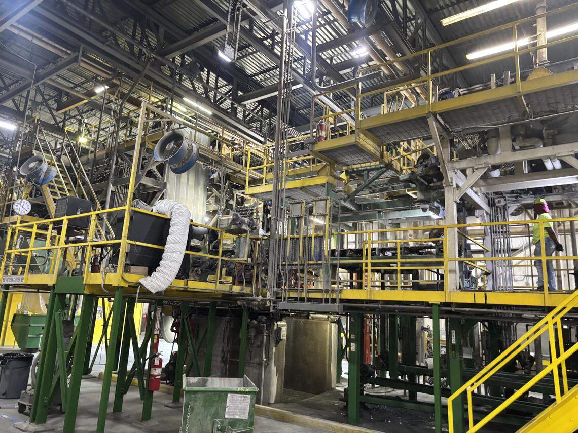 Fiberglass mat sheets are run through Saint-Gobain’s CertainTeed shingles manufacturing plant in Oxford, N.C., on July 9, 2025.