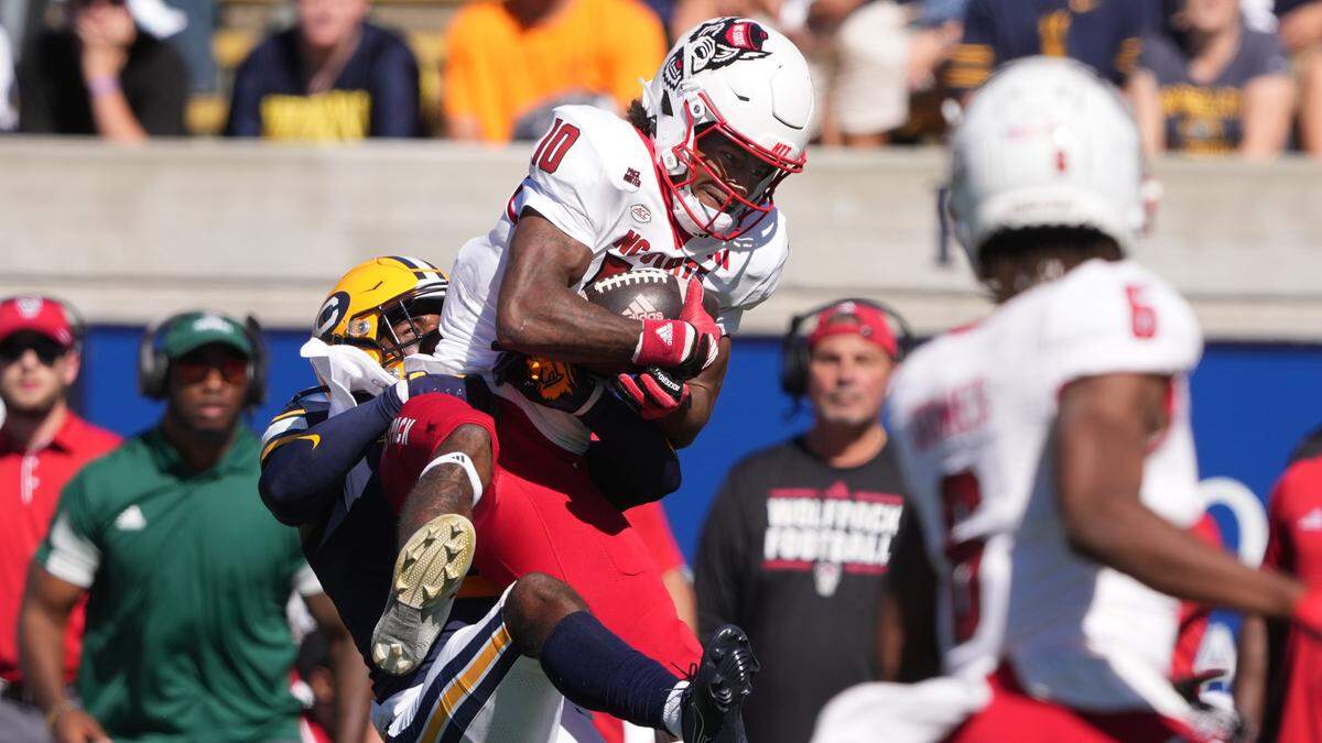 North Carolina State Wolfpack wide receiver Kevin Concepcion (10) secures a catch against defensive back Craig Woodson (left) during the second quarter at California Memorial Stadium.