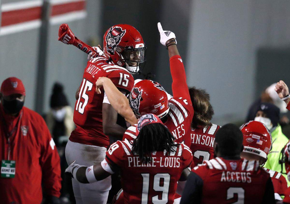 N.C. State cornerback Aydan White (15) celebrates with the turnover bone after intercepting the ball during the second half of N.C. State’s 15-14 victory over Liberty at Carter-Finley Stadium in Raleigh, N.C., Saturday, Nov. 21, 2020.