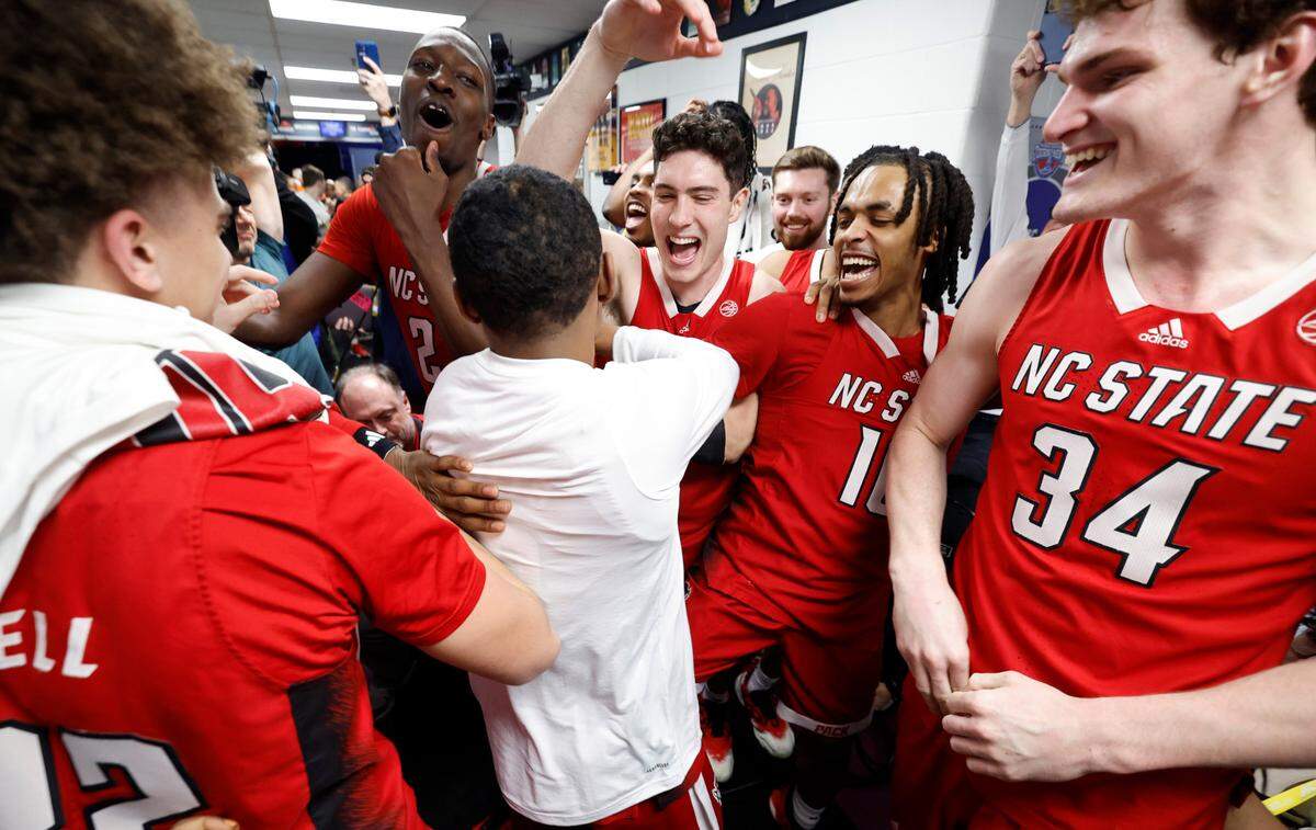 The Wolfpack team celebrates with KJ Keatts, center, after he placed N.C. State’s sticker on the board after N.C. State’s 83-65 victory over Syracuse in the second round of the 2024 ACC Men’s Basketball Tournament at Capital One Arena in Washington, D.C., Wednesday, March 13, 2024.