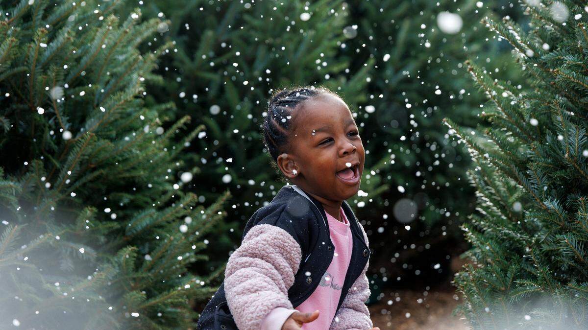 Three-year-old Meilani Rogers plays in artificial snow at the North Carolina State Farmers Market. Experts weigh in on whether N.C. could get a white Christmas this year.